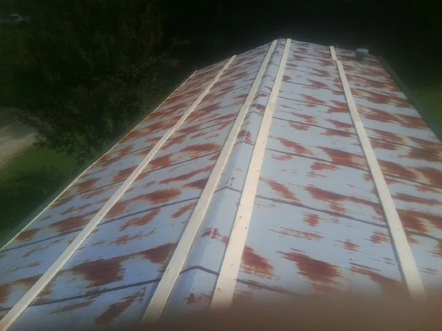 Rusted metal roof panels with new wood purlins before replacement — Storm Damage Roof Repair in Auburn by Roofing Brothers
